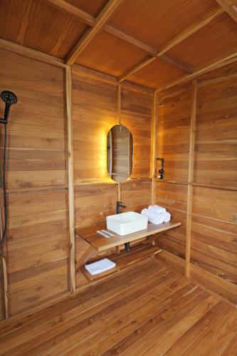 a bathroom with a sink in a wooden wall at Terra Clementia in Watukarung