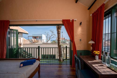 a room with a balcony with a view of a palm tree at Hill Village Phu Yen in Phú Hiệp (2)