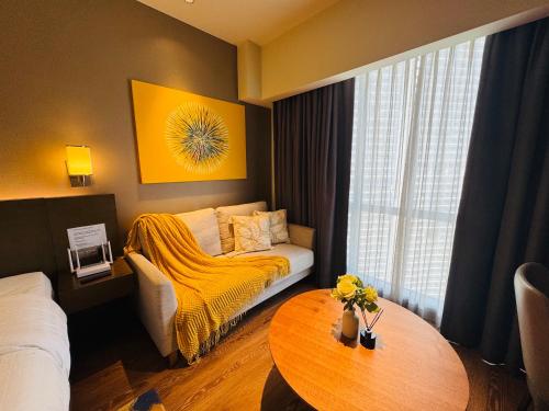 a hotel room with a bed and a table at Hotel Residences at ACQUA Tower near Rockwell Makati in Manila