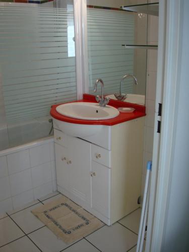 une salle de bain avec un lavabo et une baignoire dans l'établissement résidentiel, à La Rochelle