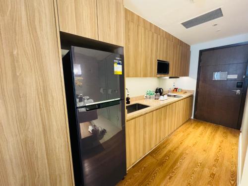 a kitchen with a large black refrigerator in a room at Hotel Residences at ACQUA Tower near Rockwell Makati in Manila