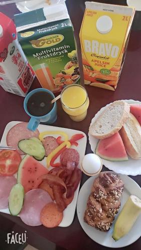 a table with plates of food and a box of bread at Vingåker Hotell in Vingåker
