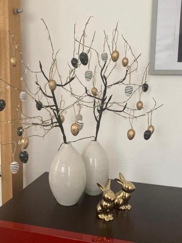 two white vases sitting on a table with christmas decorations at Domo de Logu TÀTARI ANTIGA in Sassari