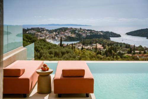 a balcony with two chairs and a view of the water at Sivota Sun Side Serenity in Sivota