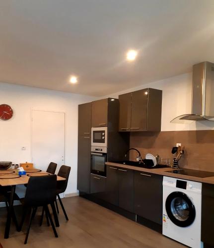 a kitchen with a table and chairs and a microwave at Logement calme en Morvan in Gien-sur-Cure