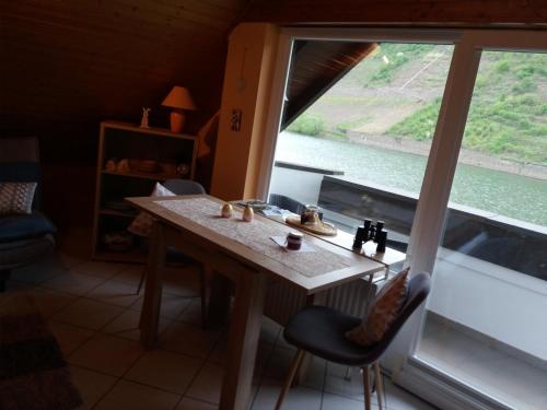 a table and chairs in a room with a large window at Altes Fachwerkhaus Mutter Mosel in Löf