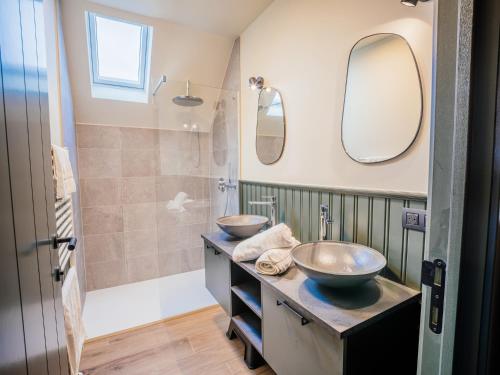 デ・パンネにあるVillage Normandieの洗面台2つとシャワー付きのバスルーム