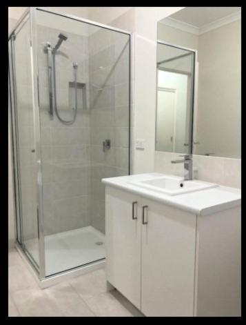 a bathroom with a shower and a sink and a mirror at Serenity Home 11 by Hiverooms in Pakenham