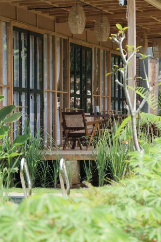 a porch of a house with a chair and plants at Terra Clementia in Watukarung