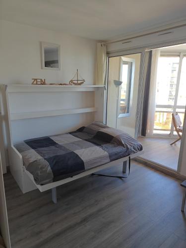 un lit blanc dans une chambre avec une fenêtre dans l'établissement Studio cosy vue mer, à Canet
