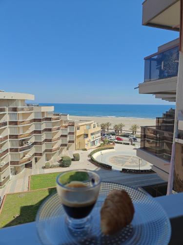 - une table avec un bol de nourriture sur une table avec vue sur la plage dans l'établissement Studio cosy vue mer, à Canet