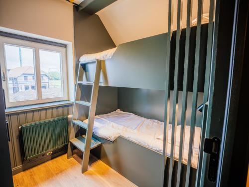 デ・パンネにあるVillage Normandieの二段ベッド1組と窓が備わる客室です。
