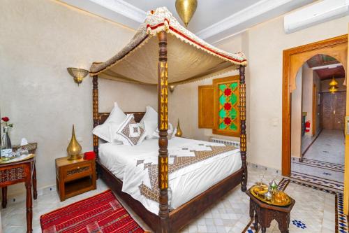 a bedroom with a four poster canopy bed at Riad Diamond Of Marrakech & Spa in Marrakech
