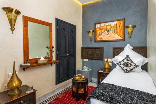 a bedroom with a bed and a mirror and a bed sidx sidx sidx at Riad Diamond Of Marrakech & Spa in Marrakech