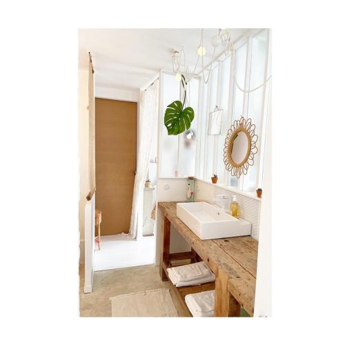 une salle de bain avec un lavabo et un miroir dans l'établissement Maison atypique, à Anglet