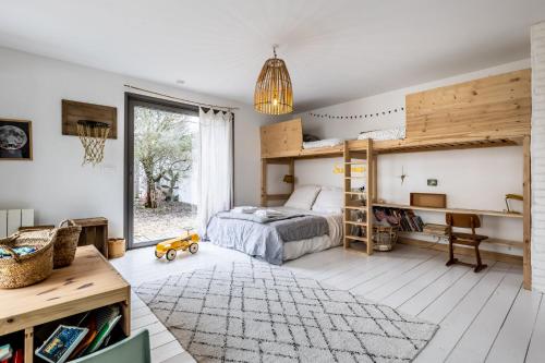 une chambre avec un lit superposé et un bureau dans l'établissement Maison atypique, à Anglet