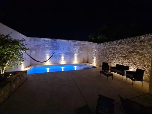a swimming pool with lights in a stone wall at night at Casa Galeria Campeche in Campeche