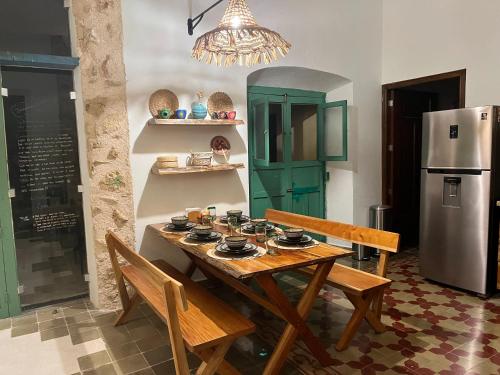 a dining room with a table and a refrigerator at Casa Galeria Campeche in Campeche