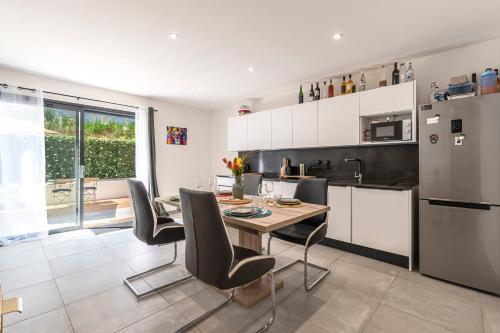 une cuisine avec une table, des chaises et un réfrigérateur dans l'établissement Le Balordo - Duplex climatisé, à Bastelicaccia