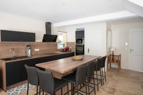 une cuisine avec une table et des chaises en bois dans l'établissement Maison Cocoon Lourmarin 6 personnes, à Lourmarin