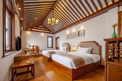 A bed or beds in a room at Nanxun Boyang New Century Mingting Resort Hotel