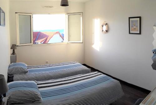 deux lits dans une chambre avec une fenêtre dans l'établissement Mer en Vue - 2 Chambres- 4 Personnes, à Fécamp