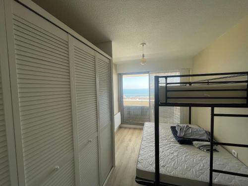 ein Schlafzimmer mit Etagenbett und Fenster in der Unterkunft L'air Marin Clim&Parking in Sète