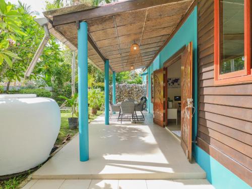 a porch of a house with blue columns at Beachfront Wooden Beach House 3br Sunset View in Taling Ngam Beach