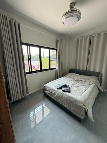 a bedroom with a bed and two large windows at The Wing Pool Villa Surin in Surin