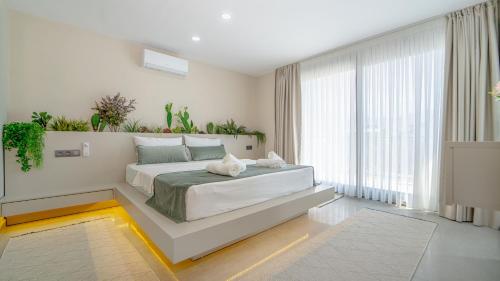 a bedroom with a large bed with plants on the wall at Oasis Retreat Lux and Elegance in Fethiye