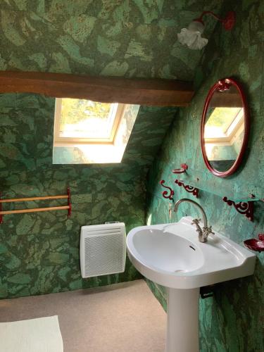 une salle de bain avec un lavabo et un miroir dans l'établissement La Béchetière, à Parcé-sur-Sarthe