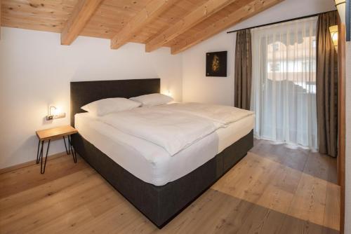 a bedroom with a large bed and a window at Natural Deluxe Apartments Alpbach in Alpbach