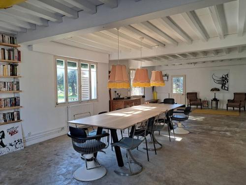 Cette grande chambre comprend une grande table et des chaises. dans l'établissement Ruisseau, à Lévignacq