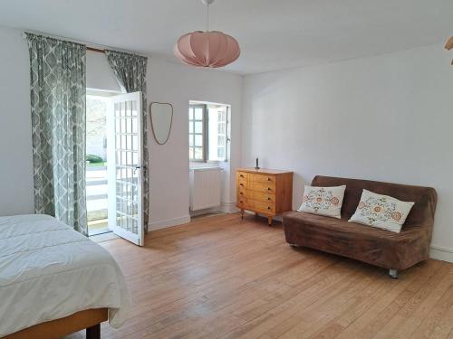 - une chambre avec un lit, un canapé et une commode dans l'établissement Ruisseau, à Lévignacq