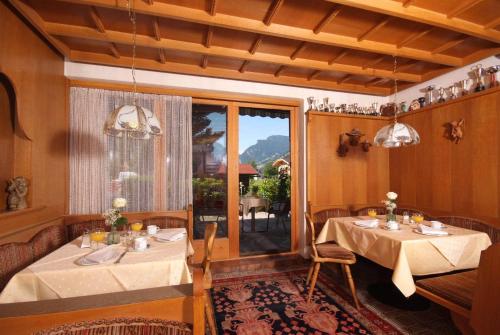 ein Esszimmer mit 2 Tischen und einem Fenster in der Unterkunft Hotel Garni Maximilian in Zell am Ziller