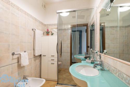 a bathroom with a blue sink and a mirror at Few steps from the sea in Golfo Aranci