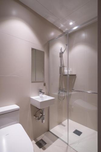 a bathroom with a toilet and a sink and a shower at Trip made in Busan