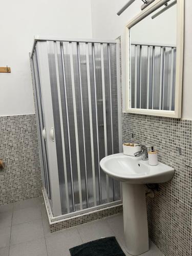 a bathroom with a sink and a shower with a mirror at B&B Al Vecchio Pontile Sea View in Marsala