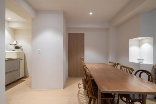 a kitchen and dining room with a wooden table and chairs at Trip made in Busan