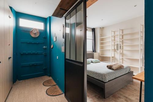 a bedroom with a blue door and a bed at La Fabrique à Souvenirs in Saint Malo