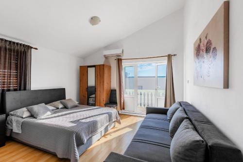 a bedroom with a bed and a couch at Apartments Papic in Vrsi