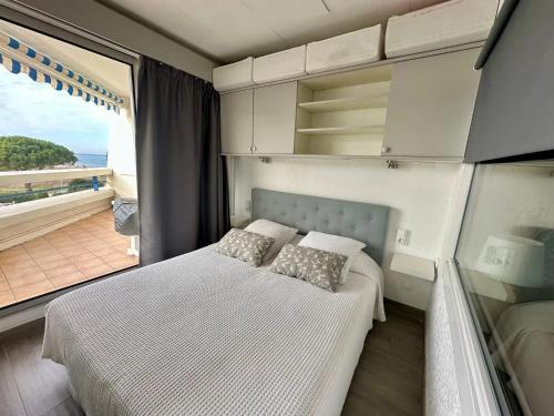 une chambre avec un lit et une grande fenêtre dans l'établissement Appartement charmant à Le Grau-du-Roi avec piscine, au Grau-du-Roi