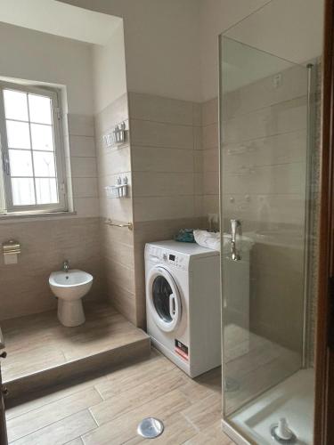 a bathroom with a washing machine and a toilet at Rory House in Pontecorvo