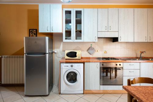 a kitchen with a refrigerator and a washing machine at Homiday - Via Gramsci Giallo in Pineto