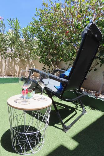 a chair and a table with wine glasses on it at Refreshing Oasis in El Médano