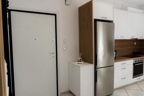 a kitchen with a stainless steel refrigerator and white cabinets at StelAnna-Apartments in Rethymno Town
