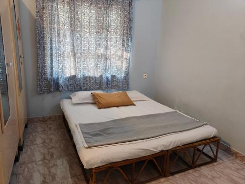 ポンディシェリにあるVilla de Colasの窓のある部屋にある小さなベッド