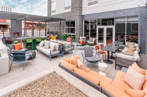 an outdoor patio with couches and tables and chairs at Hilton Garden Inn Albuquerque Uptown in Albuquerque