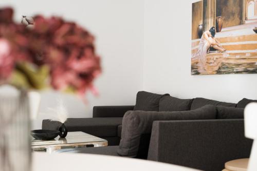 a living room with a couch and a vase of flowers at StelAnna-Apartments in Rethymno Town