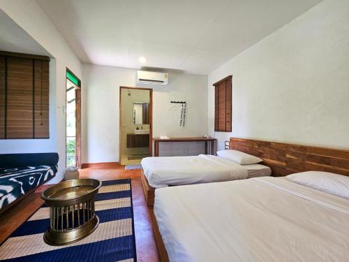 a hotel room with three beds and a bathroom at NernJamsai in Sop Poeng